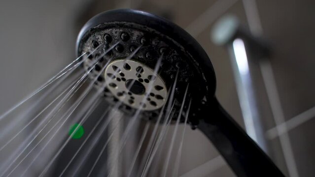 Close up Shower head with Water Drops Splashing out and Running from Faucet in Bathroom Flowing in Slow Motion shot 