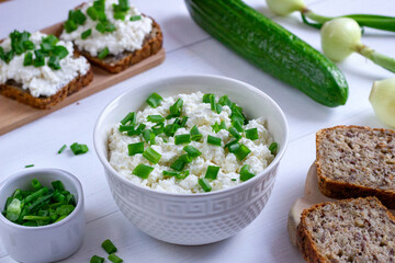  A healthy breakfast consisting of cottage cheese with chives, wholemeal bread and fresh cucumber