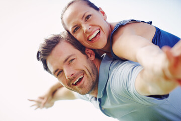 Fototapeta premium Im in this heart and soul. A handsome man piggybacking his loving wife outdoors.