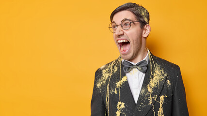 Horizontal shot of emotional young man exclaims loudly keeps mouth opened expresses negative...