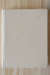 rough book with plain cloth cover on wood