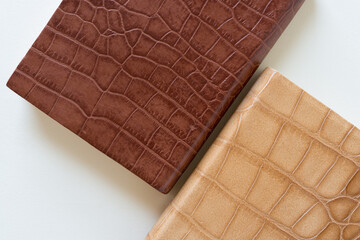 two leather (or bonded leather) covered books on a light background