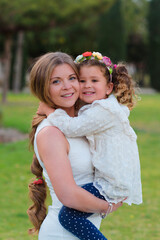 Daughter hugs her mother with feeling in the park outdoors