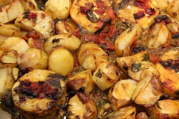 Whitefish fillets, potatoes, tomatoes are cooked in the oven. Closeup view, shallow depth of field