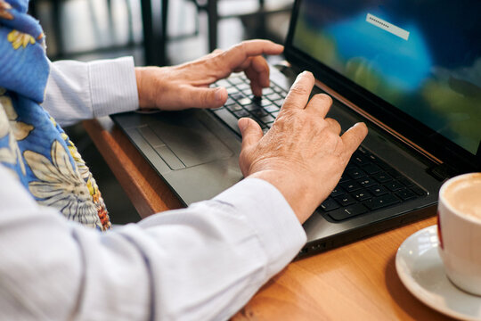 Close-up of a mature woman working remotely with her laptop