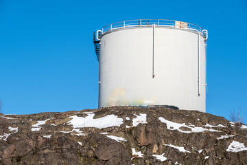 Closeup of an abandoned oil container standing on top of a granite hill