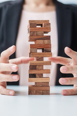 Businesswoman hand cover wooden block on the tower. Business planning, Risk Management, Solution,...