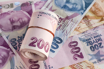 Two Hundred Turkish Banknotes rolled up on paper money.Monetary background