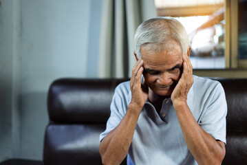 Asian senior man patients headache hands on forehead, Health problem retired asian old man hands touching and massage head while Relieve pain. health concept. Asian Older man suffering from headache.