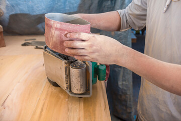 Removing a roll of worn sandpaper from a sanding machine or belt sander. Leveling the surface of a...