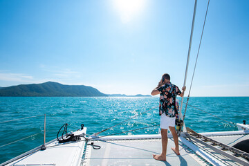 Portrait of Caucasian man enjoy luxury lifestyle catamaran boat sailing with looking at beautiful...