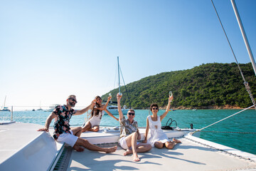 Group of Caucasian people friends enjoy luxury party drinking champagne together while catamaran...