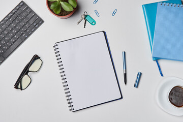 Bright office workspace. Work space with notepad, keyboard, coffee and glasses. Work space table desk. Flat lay, top view, copy space