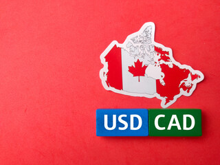 Top view colored block and canada flag with text USD CAD on red background.