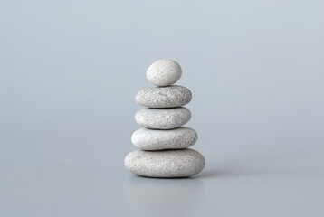 Fototapeta na wymiar Pebbles stack on grey background, zen balance meditation minimal concept