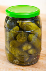 Pickled cucumbers with spices in glass jar on a wooden surface. High quality photo