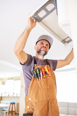 an electrician repairs a home air conditioner