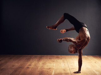Dedication, passion, commitment. Male dancer performing an acrobat move.