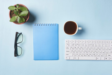 Bright office workspace. Work space with notepad, keyboard, coffee and glasses. Work space table desk. Flat lay, top view, copy space