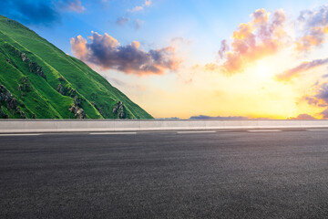 Empty asphalt road and green mountain with beautiful sky clouds at sunset