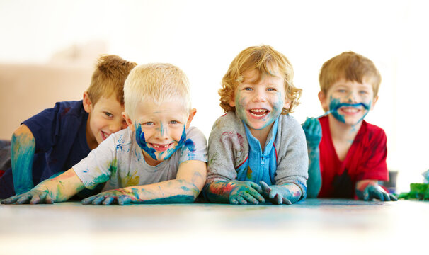 Kids will be kids. Portrait of four cute little boys covered in paint.