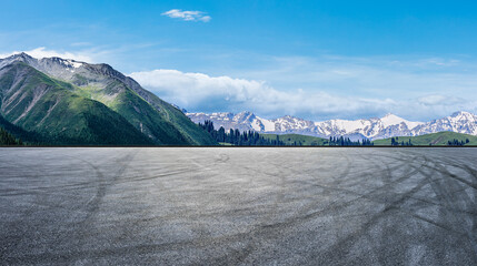Empty asphalt road and snow mountain nature scenery under blue sky. Road and mountains background.