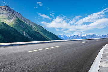 Empty asphalt road and mountain nature scenery under blue sky. Road and mountains background.