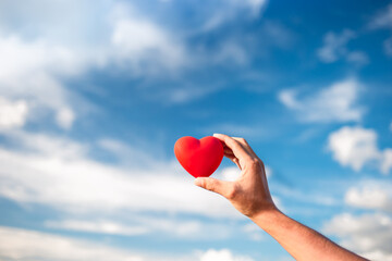 Fototapeta premium hand holding beautiful heart up to the sky.