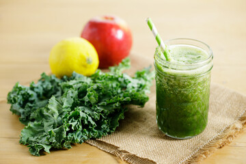 Green smoothies of kale, apple and lemon in a glass.