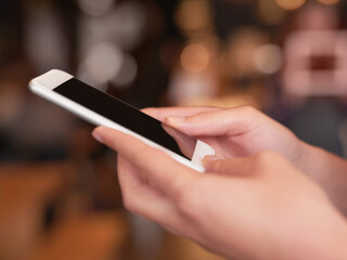 Stay in touch. Cropped shot of an unrecognizable woman using her cellphone in a coffee shop.