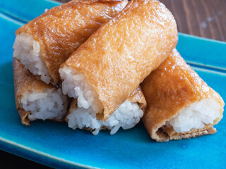 いなり寿司。酢飯を甘く煮込んだ油揚げで包んだ日本の料理。