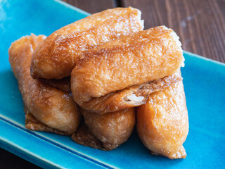 いなり寿司。酢飯を甘く煮込んだ油揚げで包んだ日本の料理。