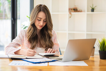 Beautiful Asian woman working on a laptop computer at the office. businesswoman looking at financial statistics data analysis chart graph profit growth business idea