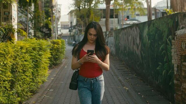 a beautiful trans woman chatting while walking down the street