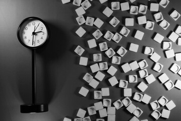 Standing clock in the left and the scrabble game letter tiles in the right side on red background. One third composition.