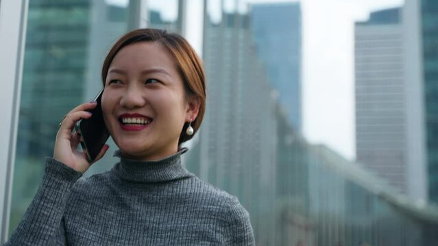 Happy Young Woman Talking with Friend on Cellphone with Big Laugh and Walking Casually in Street at Daytime Chengdu Sichuan China