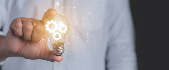 Hand of a man holding an illuminated light bulb.Idea innovation and inspiration concept.