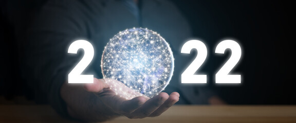 Happy new year 2022 in the hand of a businessman. 2022 Technology digital style concept.Elements of this image furnished by NASA. Elements of this image furnished by NASA.