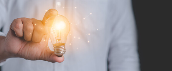 Hand of a man holding an illuminated light bulb.Idea innovation and inspiration concept.