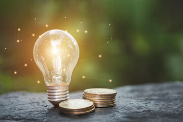 Saving energy and finance, energy stock investment, A pile of coins and light bulbs laid on the ground. Saving energy and finance concept.