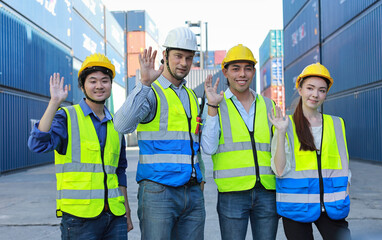 Group of multiethnic technician engineer or worker in protective uniform with hardhat standing and give high five celebrate successful together or completed deal commitment at container cargo site