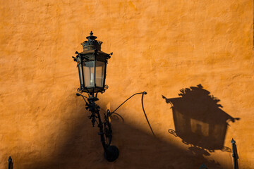 Oslo, Norway  An antique lamp and shadow on a classic orange facade in downtown.