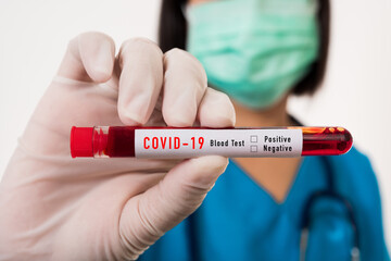 Fototapeta premium Nurse in blue uniform wear a mask holding test tube sample Coronavirus test blood in the laboratory for analyzing isolated on white background, medicine COVID-19 pandemic outbreak concept