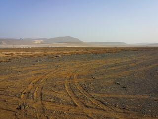 Bright sky over a rocky desert. Rough surface in a valley, dry arid African climate, hot weather in Cape Verde. Selective focus on the details, blurred background.
