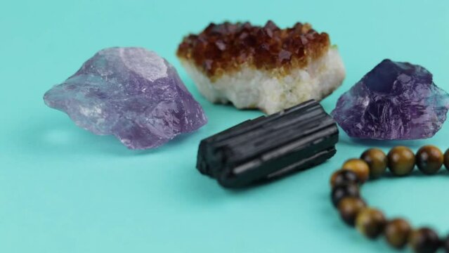 A selection of healing crystals on a light blue background. Slider shot.