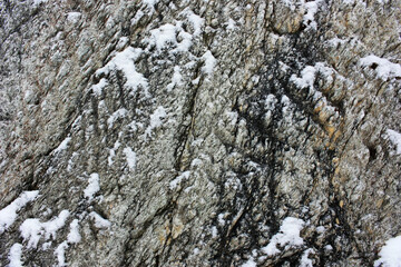 Gray stone cliff covered with snow