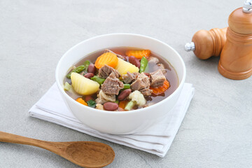 Sup daging kacang merah, clear soup with beef slices, red bean and vegetables. Served in bowl on...