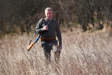 Hunter with rifle in the forest