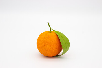 One mandarin with green leaf on white background.