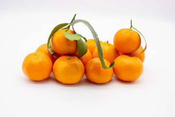 Few ripe tangerines with green leaves
